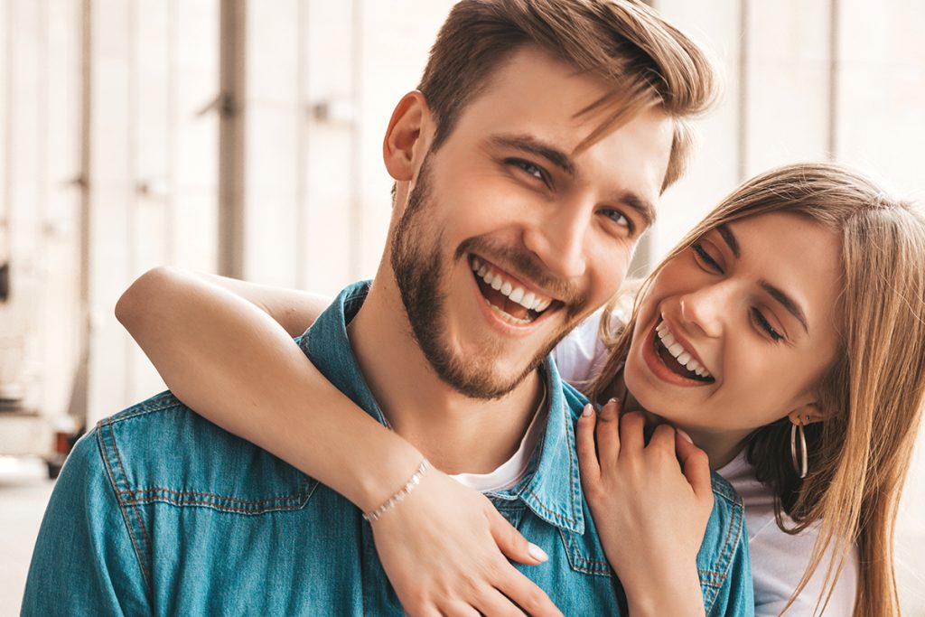 Smiling young couple enjoying a joyful moment, promoting healthy smiles and confidence in dental care.