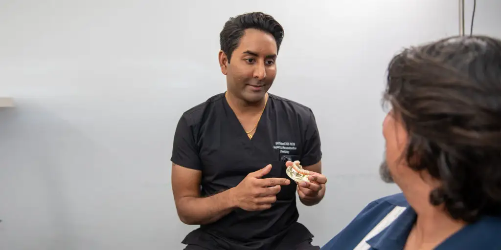 Dentist consulting with patient, discussing cosmetic dentistry options, including porcelain veneers and dental crowns, in a modern dental office setting.