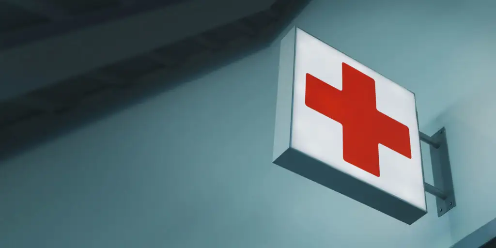 Emergency dental care sign with a red cross, symbolizing urgent dental services at Palani Center for Dental Implants in Rancho Palos Verdes.
