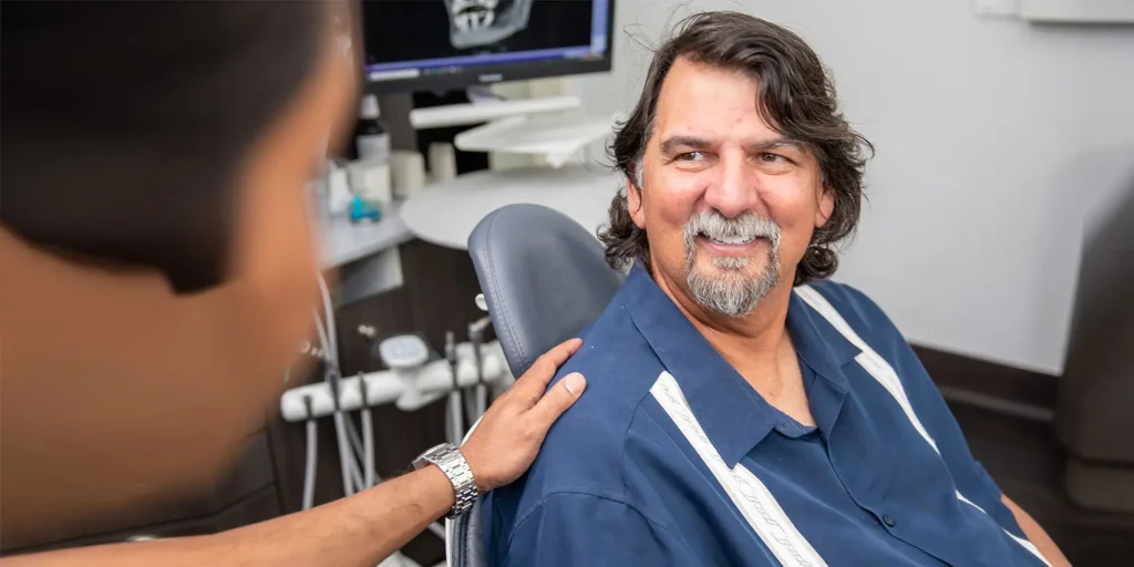 Patient smiling in dental chair, receiving personalized care at Palani Center for Dental Implants in Rancho Palos Verdes, CA.